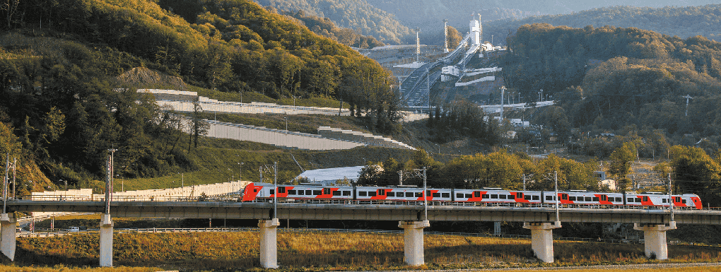 Поезд на фоне трамплинов и гор